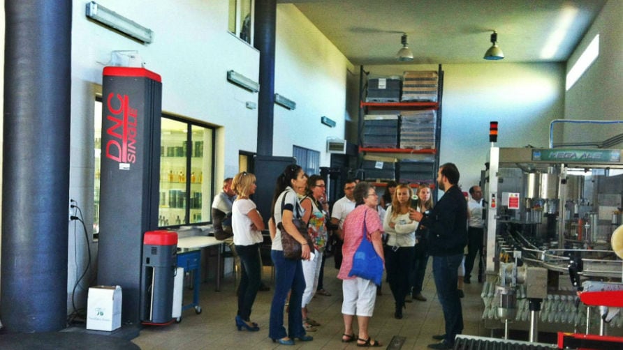 visitors listening to a guide at 'Vassilakis Estate' olive oil plant